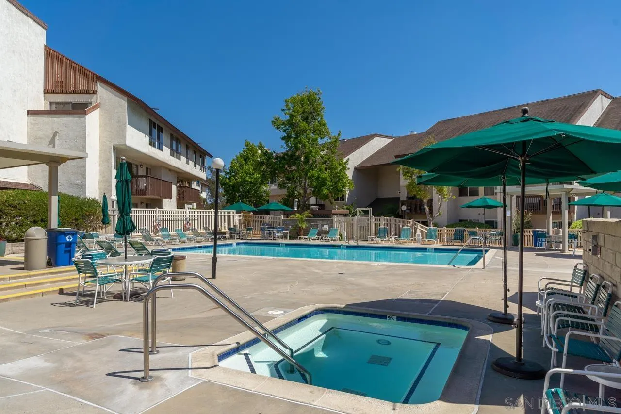 6191 Rancho Mission Road, Unit 308 San Diego, CA 92108 - Photo 28 of 31 a view of a patio with chairs and a table under an umbrella