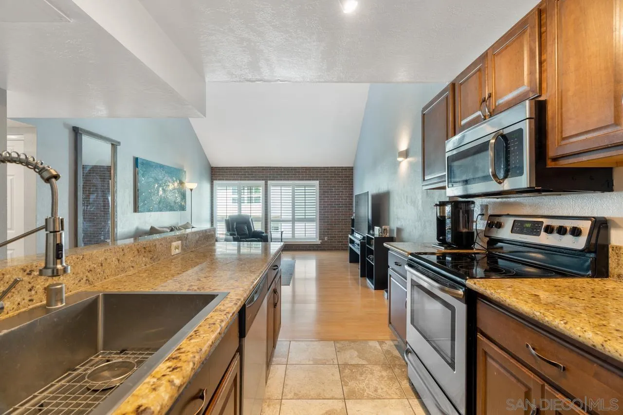 6191 Rancho Mission Road, Unit 308 San Diego, CA 92108 - Photo 8 of 31 a kitchen with lots of counter top space a sink and stainless steel appliances