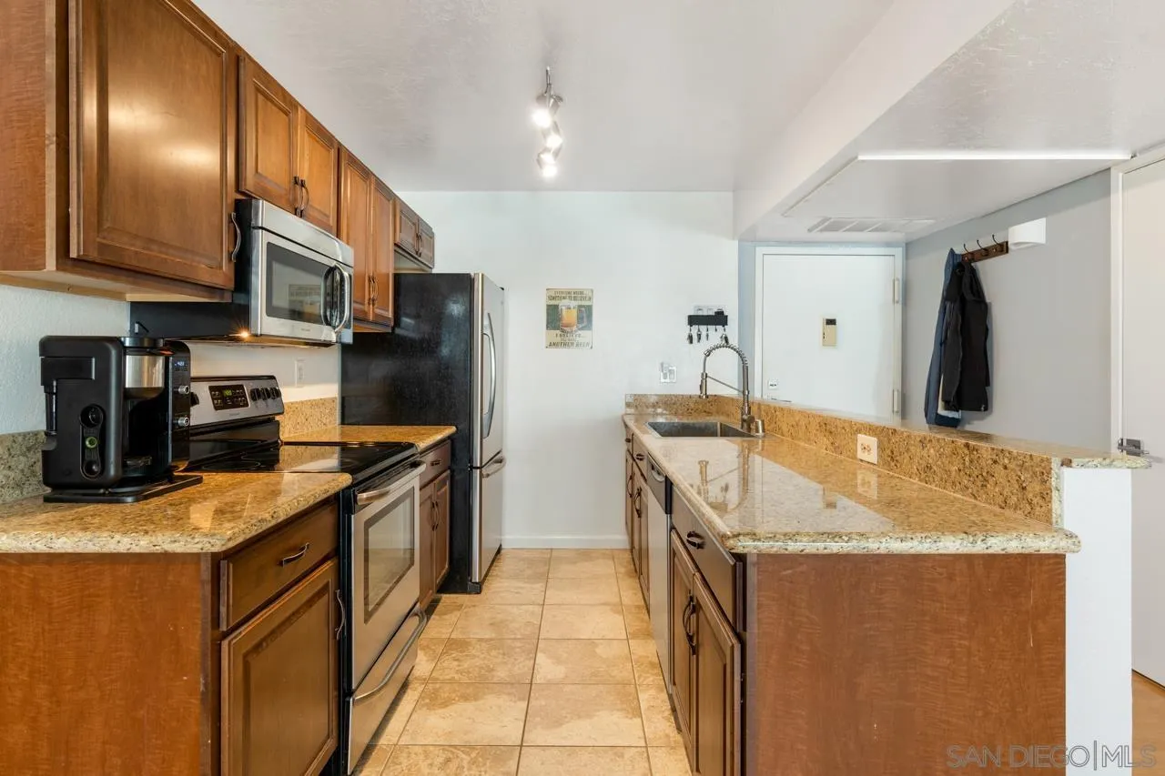 6191 Rancho Mission Road, Unit 308 San Diego, CA 92108 - Photo 9 of 31 a kitchen with stainless steel appliances granite countertop a sink stove and refrigerator