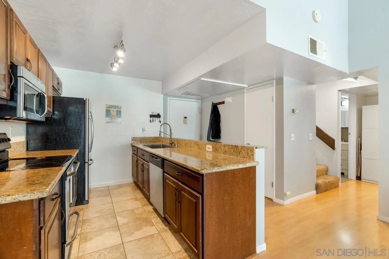 6191 Rancho Mission Road, Unit 308 San Diego, CA 92108 - Photo 10 of 31 a kitchen with stainless steel appliances granite countertop a stove and a refrigerator