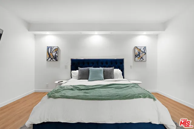 a bedroom with a bed and a painting on the wall