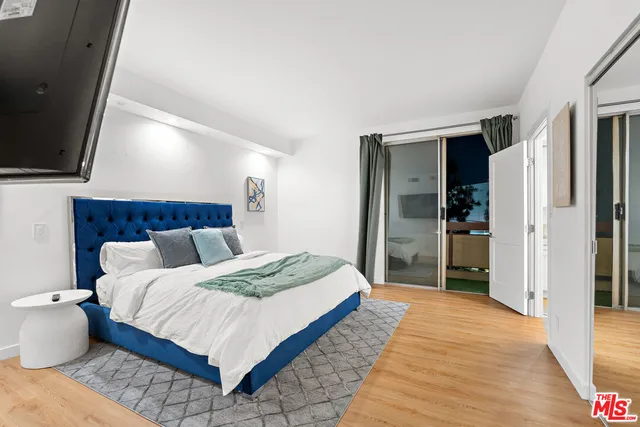 a bedroom with a bed and a flat screen tv