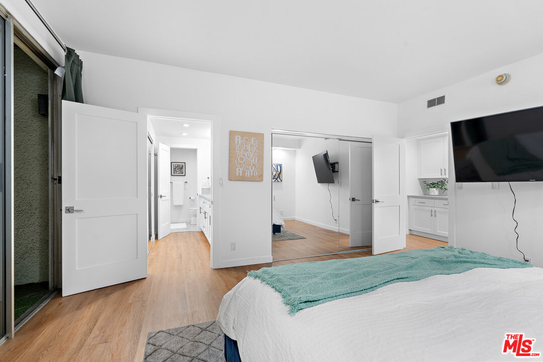321 South San Vicente Boulevard, Unit 507 Los Angeles, CA 90048 - Photo 13 of 30 a spacious bedroom with a bed and a flat screen tv
