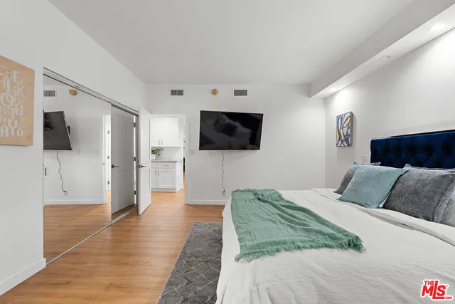 a bedroom with a bed and a flat screen tv