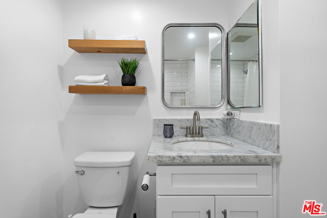 321 South San Vicente Boulevard, Unit 507 Los Angeles, CA 90048 - Photo 18 of 30 a bathroom with a granite countertop toilet sink and mirror