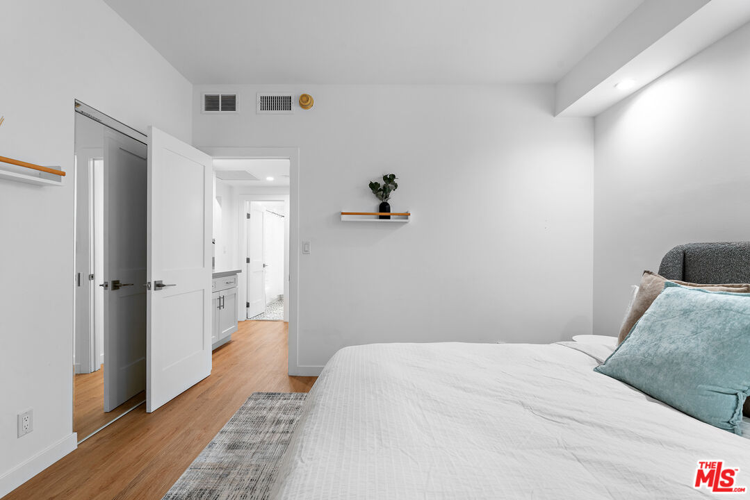 321 South San Vicente Boulevard, Unit 507 Los Angeles, CA 90048 - Photo 19 of 30 a bedroom with a bed and wooden floor