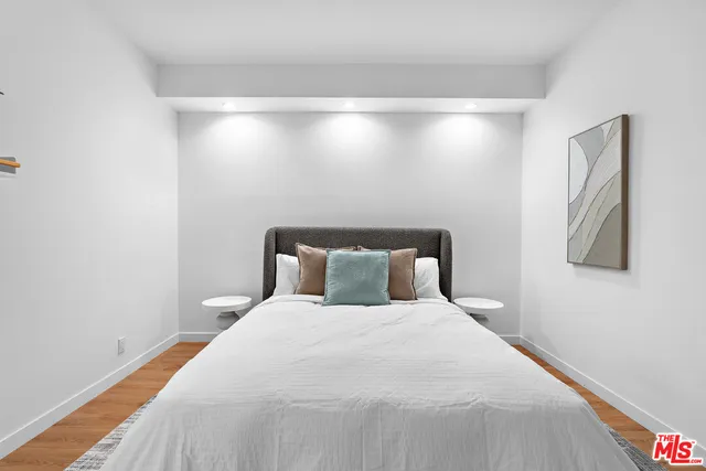 a large bed sitting in a bedroom next to a lamp