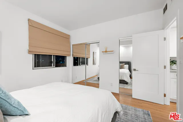 a bedroom with a bed and a view of kitchen