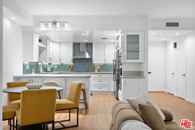 a living room with stainless steel appliances granite countertop furniture a fireplace and a view of kitchen