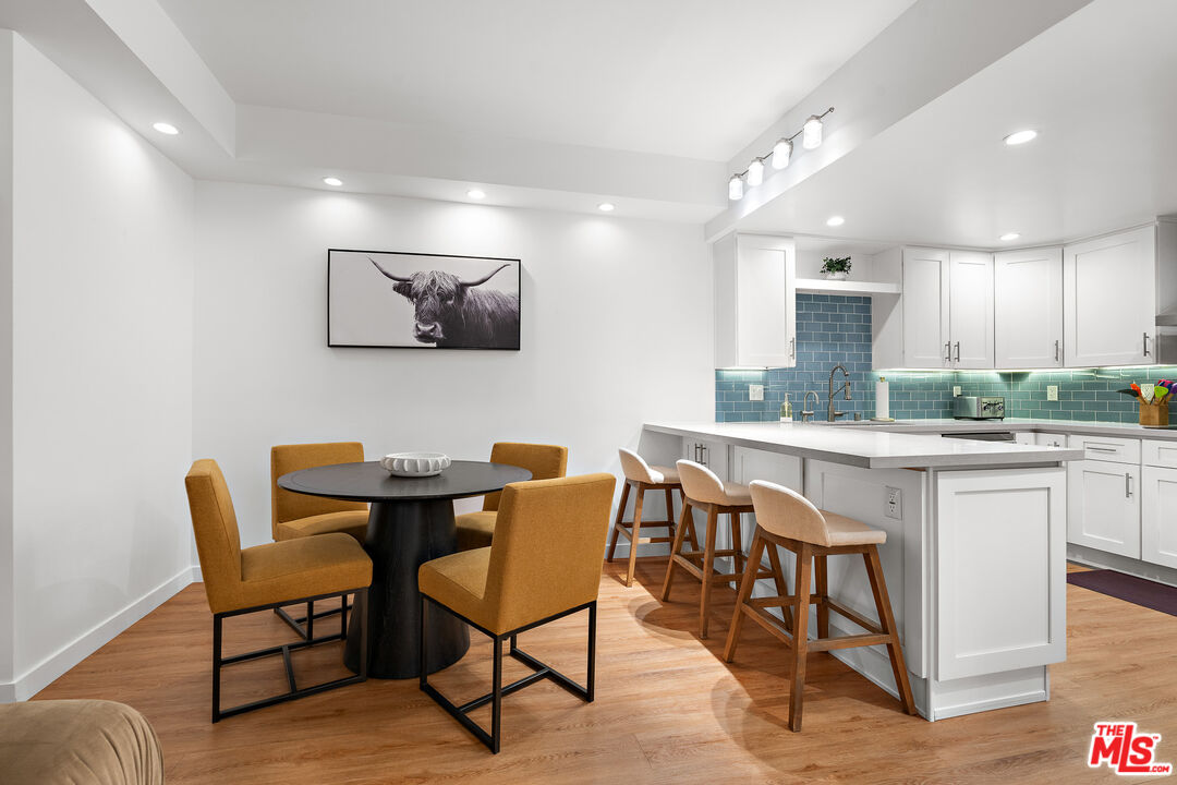 321 South San Vicente Boulevard, Unit 507 Los Angeles, CA 90048 - Photo 8 of 30 a kitchen with stainless steel appliances granite countertop a dining table chairs and a refrigerator
