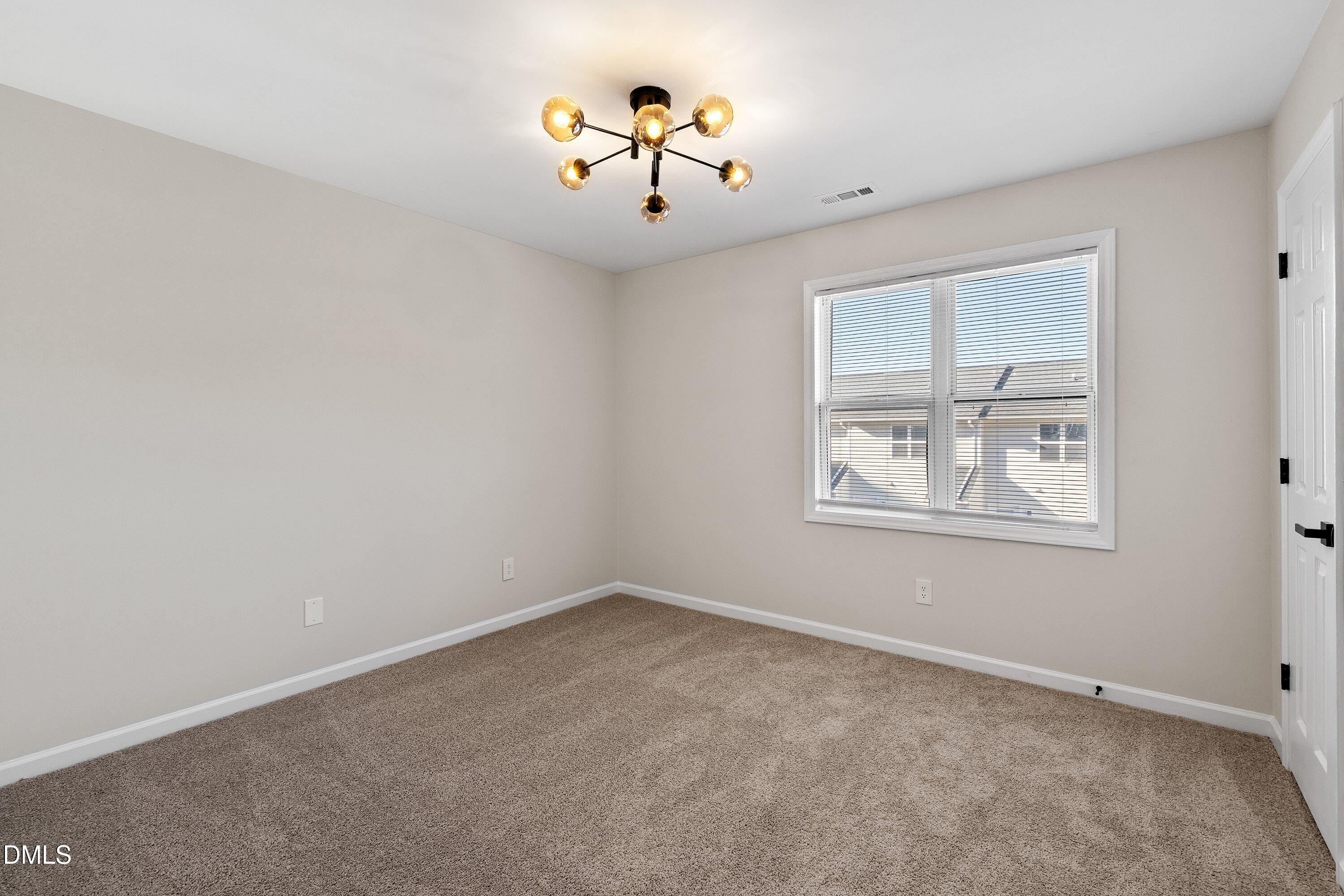 389 East Williams Street Angier, NC 27501 - Photo 19 of 26 an empty room with window and ceiling fan