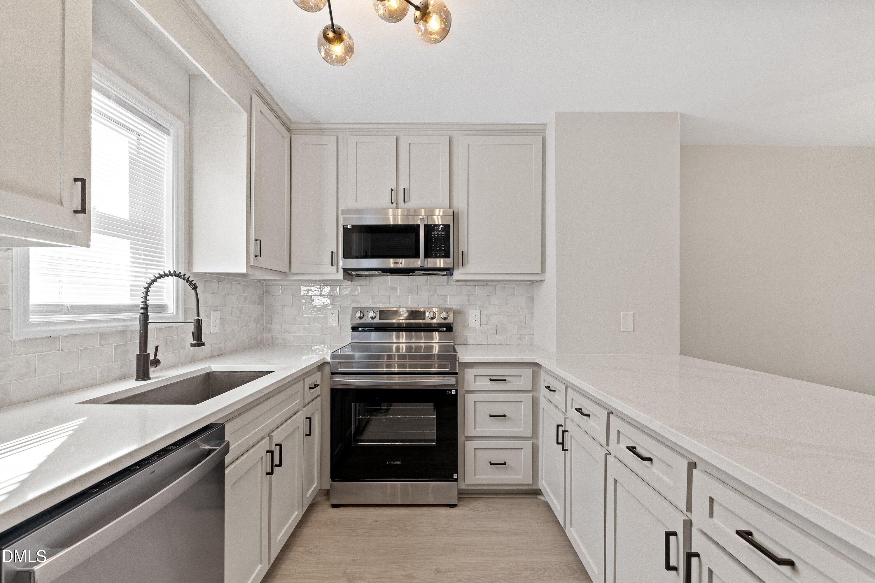 389 East Williams Street Angier, NC 27501 - Photo 5 of 26 a kitchen with stainless steel appliances granite countertop a sink stove oven a sink and dishwasher with cabinets