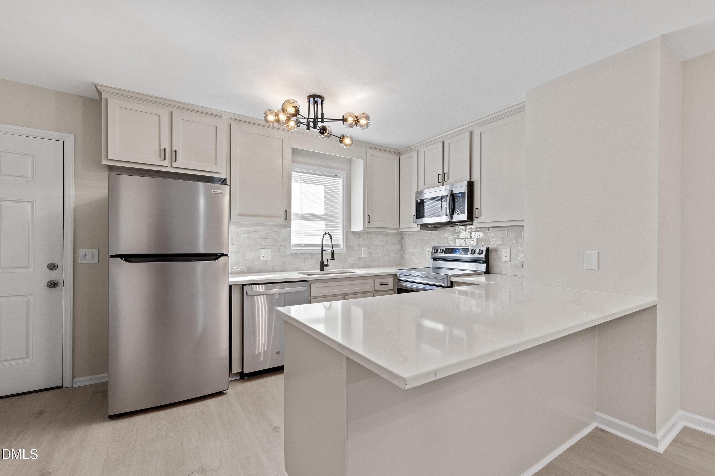 389 East Williams Street Angier, NC 27501 - Photo 6 of 26 a kitchen with a refrigerator a sink and cabinets