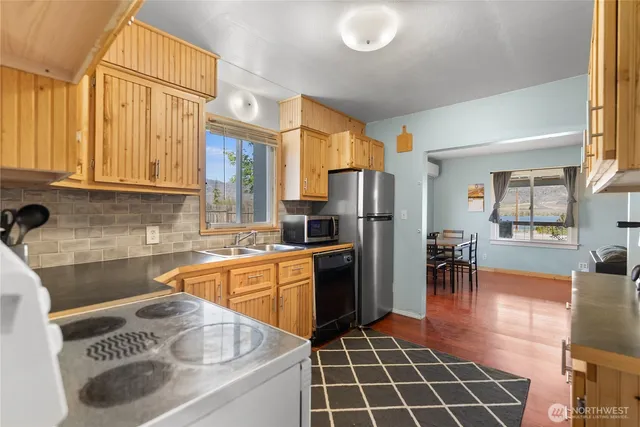 a kitchen with stainless steel appliances granite countertop a stove a sink and a microwave
