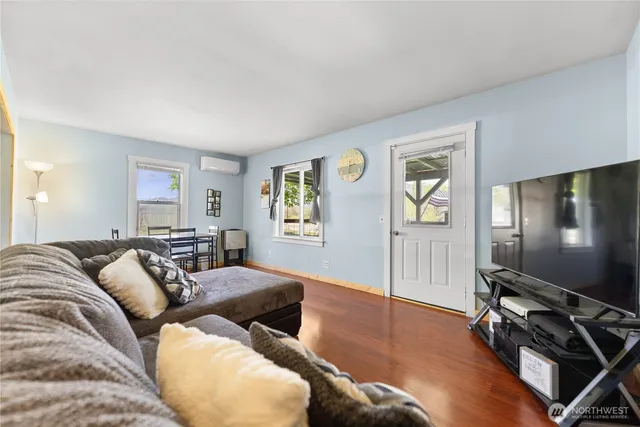 a living room with furniture flat screen tv and wooden floor