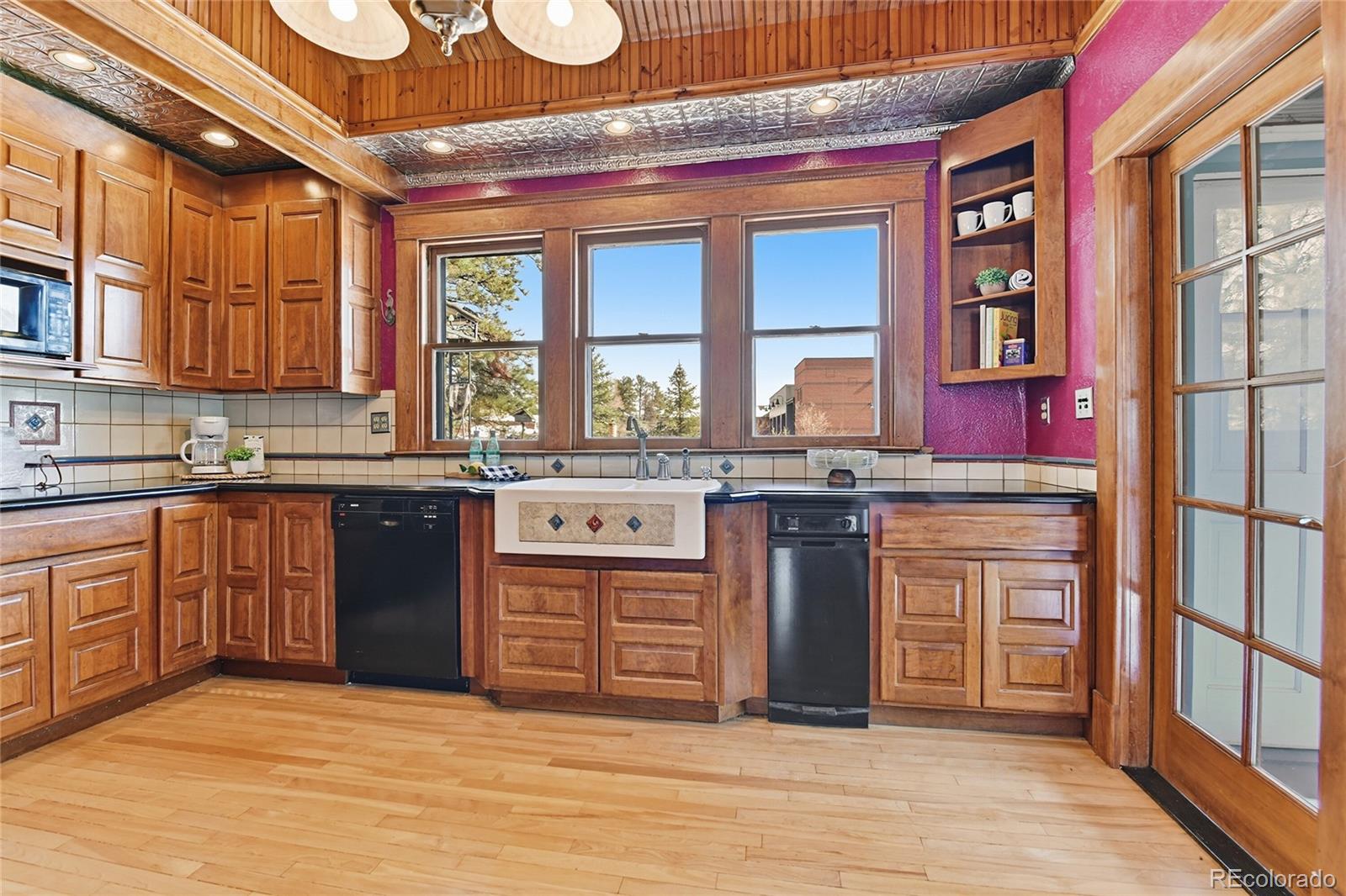 9490 Spruce Mountain Road Larkspur, CO 80118 - Photo 11 of 49 a kitchen with stainless steel appliances granite countertop a stove a sink and a microwave