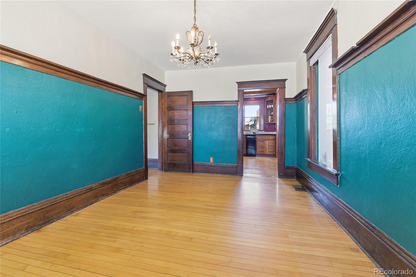 9490 Spruce Mountain Road Larkspur, CO 80118 - Photo 15 of 49 a view of a hallway with wooden floor and a chandelier