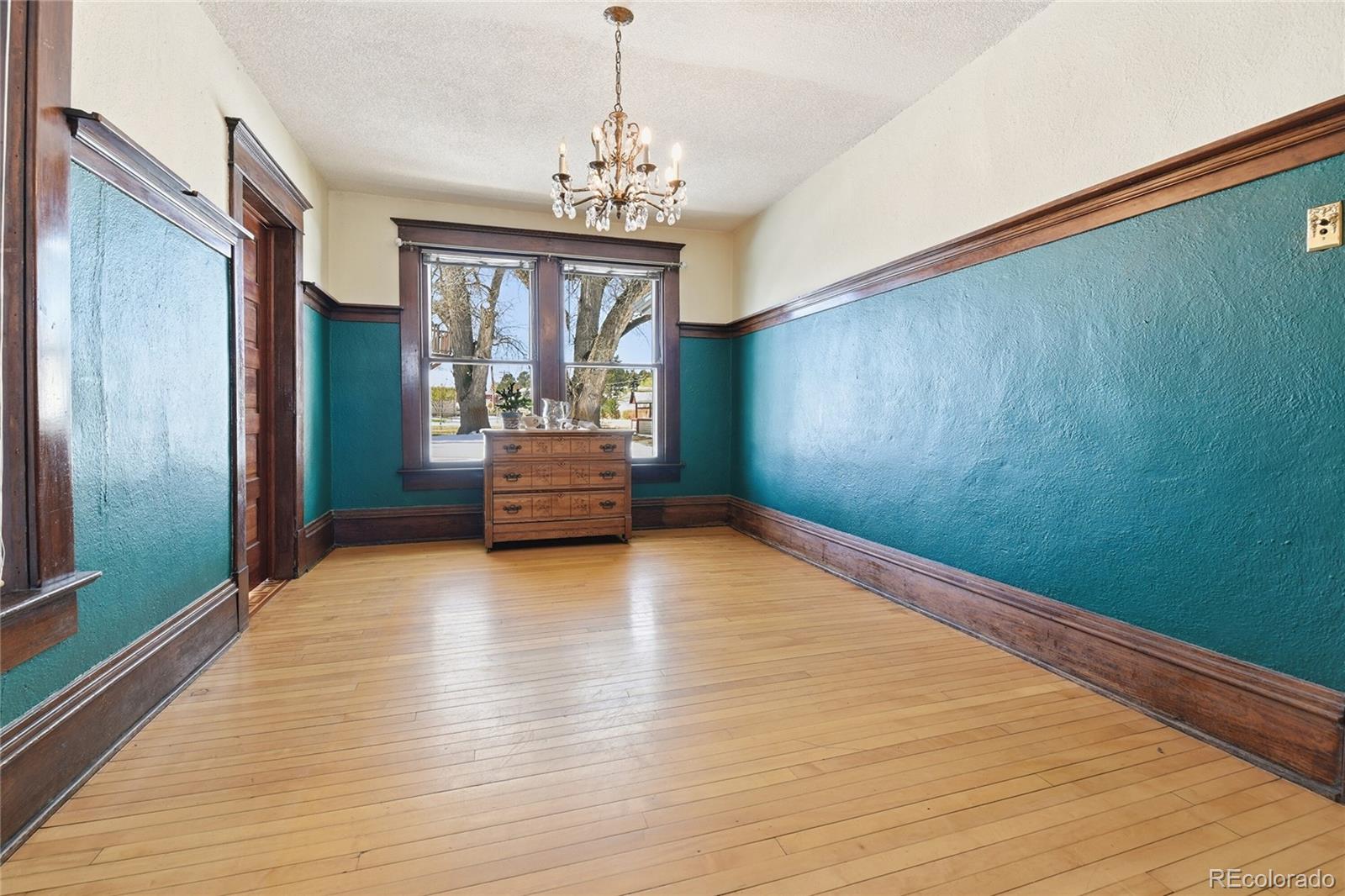 9490 Spruce Mountain Road Larkspur, CO 80118 - Photo 17 of 49 a view of an empty room with window and wooden floor