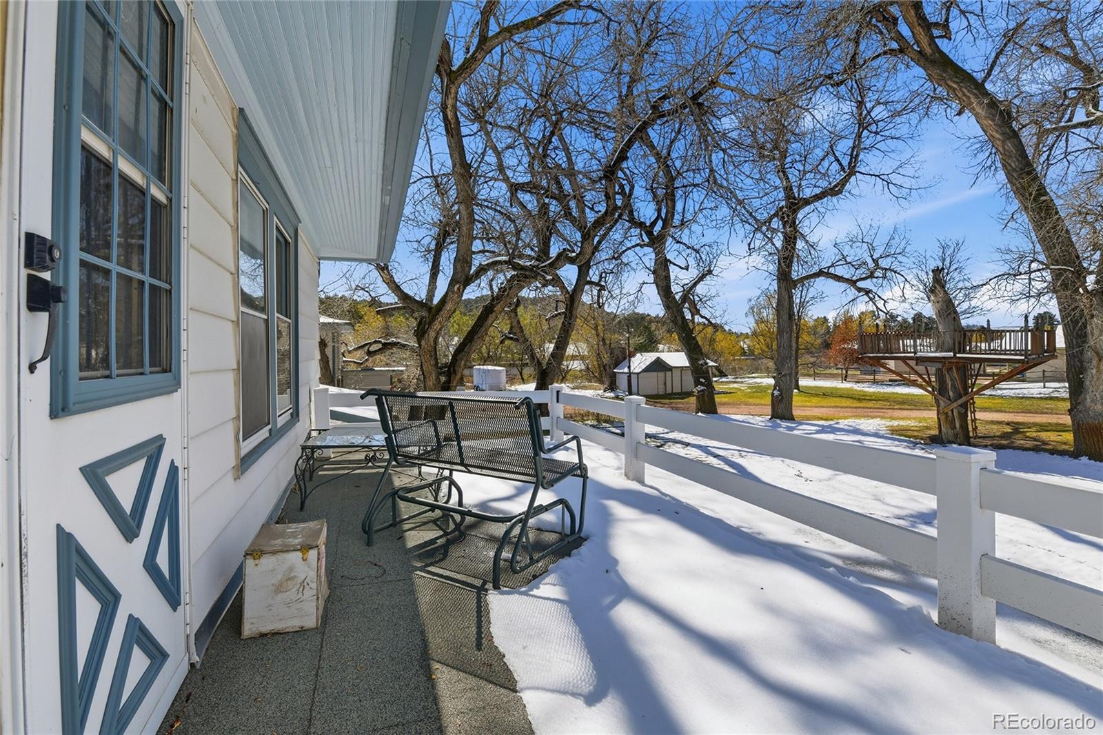 9490 Spruce Mountain Road Larkspur, CO 80118 - Photo 27 of 49 a view of building with bench and trees