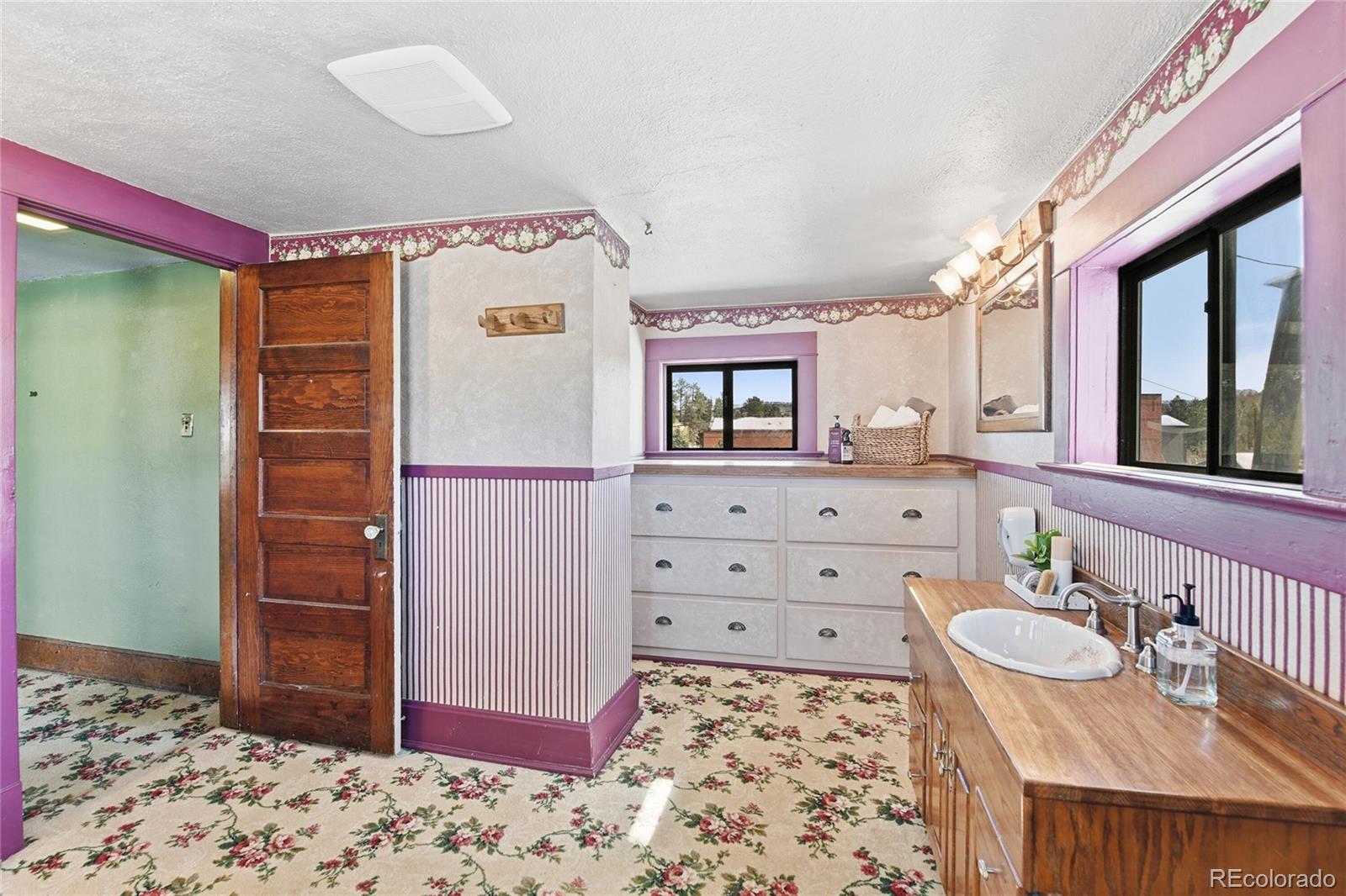 9490 Spruce Mountain Road Larkspur, CO 80118 - Photo 31 of 49 a view of a bedroom with a bed and wooden floor