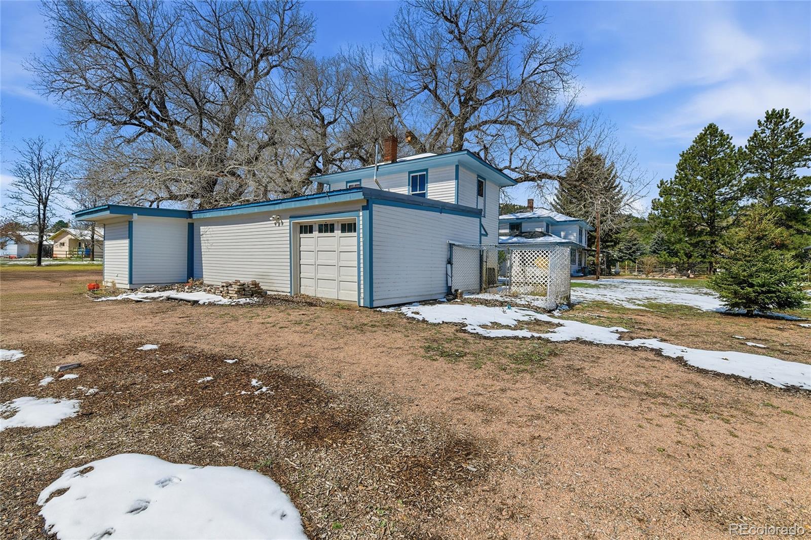 9490 Spruce Mountain Road Larkspur, CO 80118 - Photo 43 of 49 a backyard of a house with large trees and outdoor seating