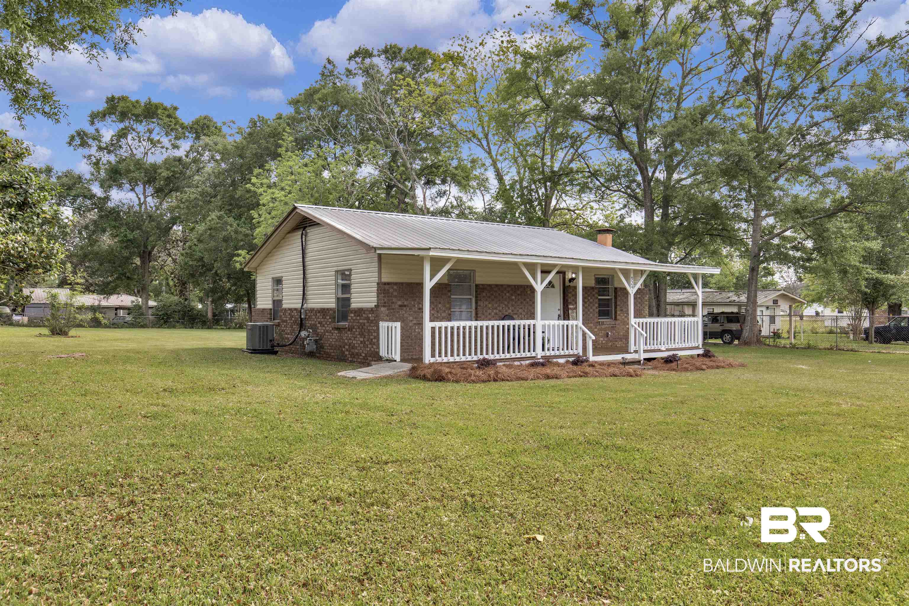 9241 Vallaris Street North Mobile, AL 36608 - Photo 3 of 17 View of front of home with a chimney, a front lawn, brick siding, and covered porch