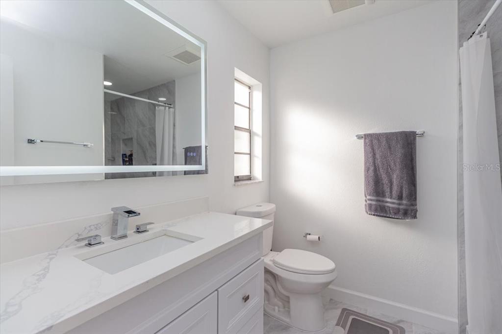7264 Lindhurst Street Spring Hill, FL 34606 - Photo 14 of 24 a bathroom with a toilet a sink a mirror and a window