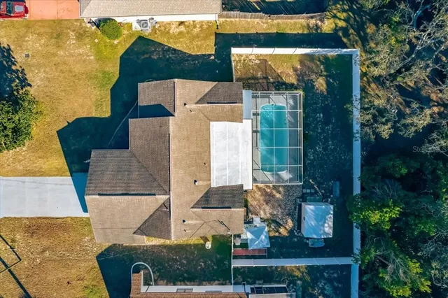 an aerial view of a house with swimming pool and wooden fence