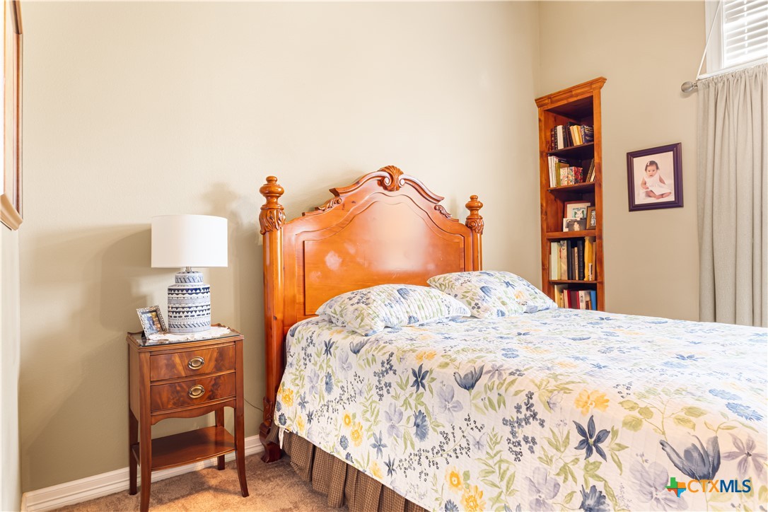 790 Spanish Grant Road Goliad, TX 77963 - Photo 22 of 41 a bedroom with a bed and a lamp on dresser
