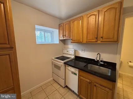 a kitchen with granite countertop a sink and a stove top oven