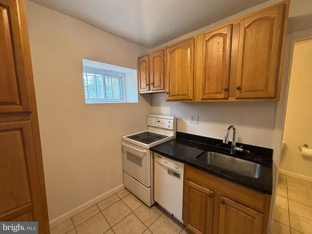 a kitchen with granite countertop a sink and a stove top oven
