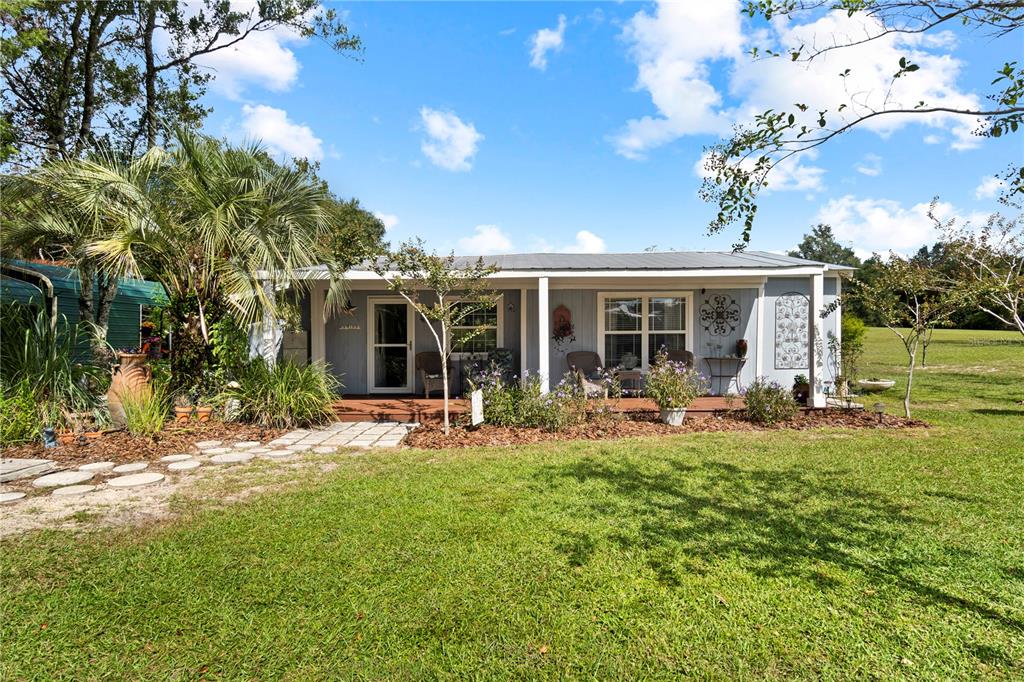 7650 Northeast 40th Street High Springs, FL 32643 - Photo 1 of 75 a front view of a house with patio and garden