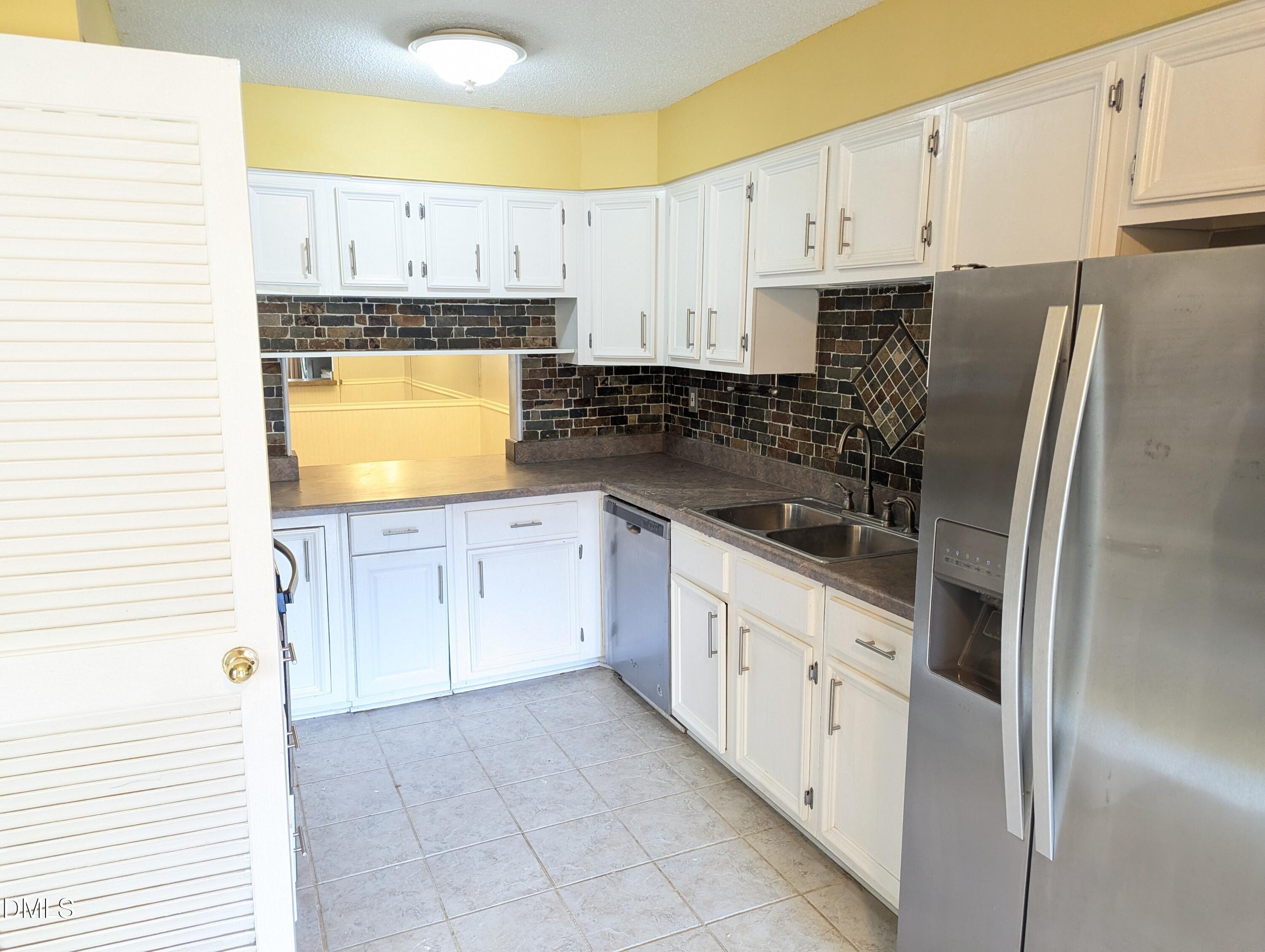 4100 Five Oaks Drive, Unit 49 Durham, NC 27707 - Photo 19 of 23 a kitchen with stainless steel appliances a refrigerator sink and cabinets