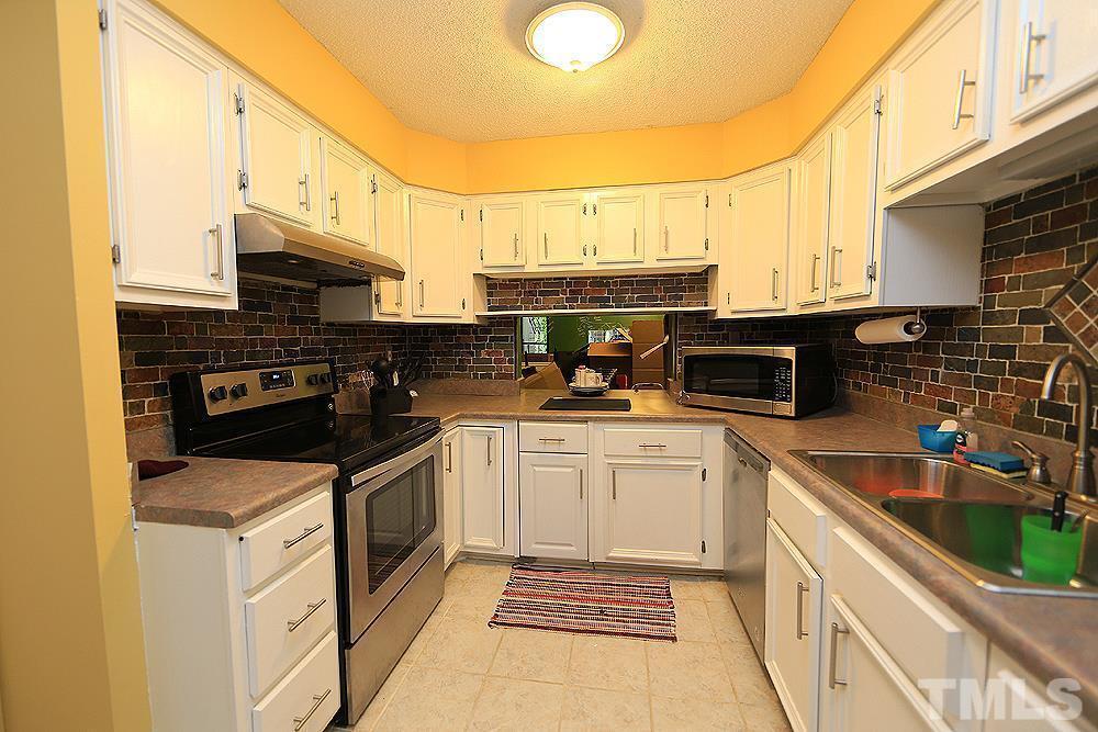 4100 Five Oaks Drive, Unit 49 Durham, NC 27707 - Photo 7 of 23 a kitchen with stainless steel appliances granite countertop a sink stove and cabinets
