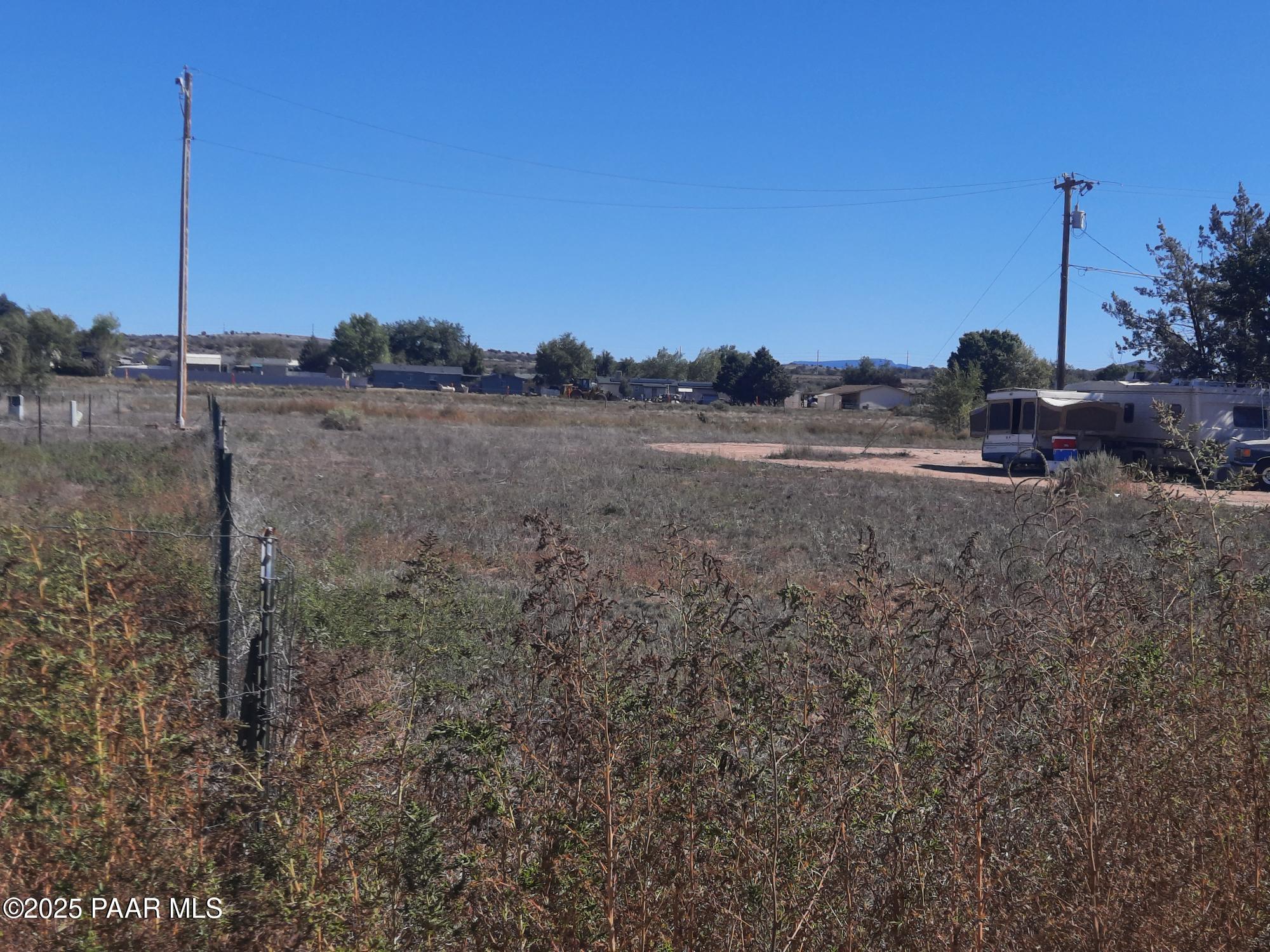 a view of a dry yard with wooden fence