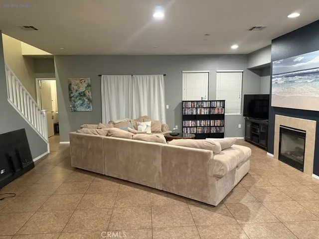 a living room with furniture a fireplace and a flat screen tv
