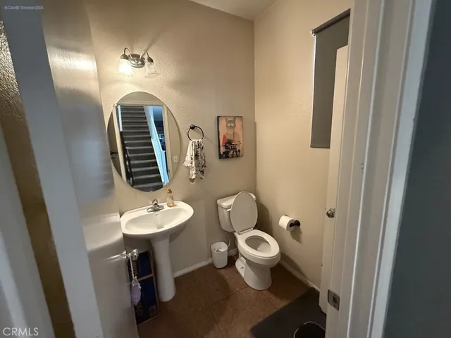 a bathroom with a toilet a sink and mirror
