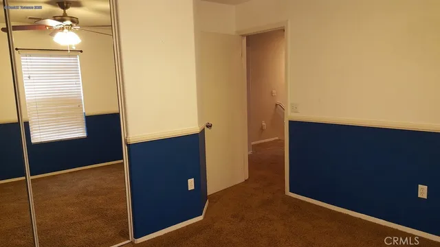 a view of a room with a ceiling fan and a window