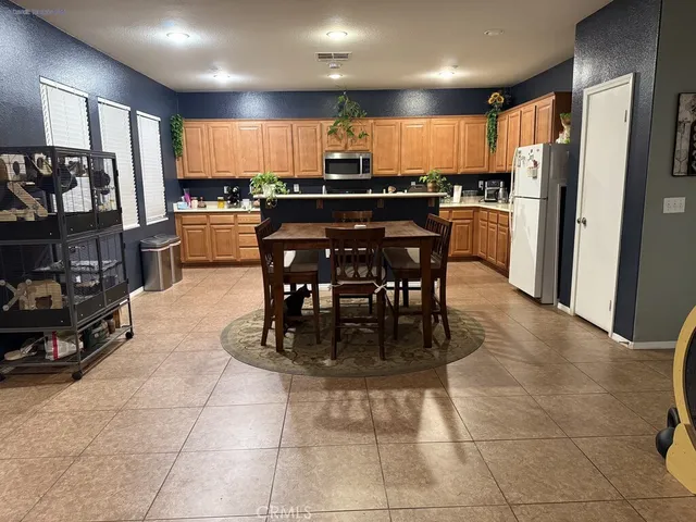a kitchen with kitchen island granite countertop a sink a counter top space appliances and cabinets