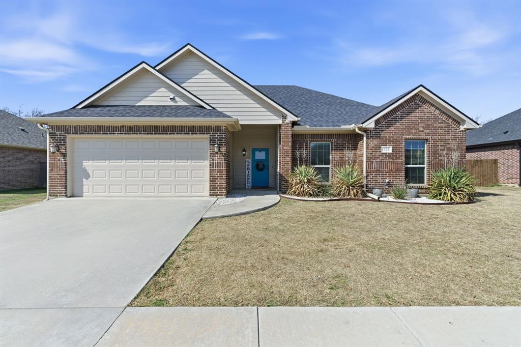 Ranch-style house with a garage, brick siding, concrete driveway, and a shingled roof