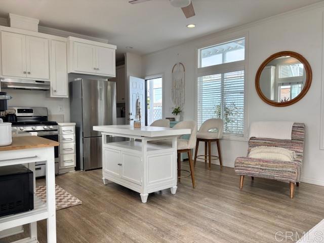 699 North Vulcan Avenue, Unit 80 Encinitas, CA 92024 - Photo 12 of 27 a kitchen with a white cabinets and chairs