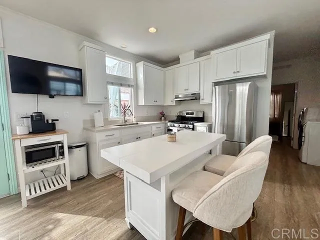 a kitchen with white cabinets and stainless steel appliances