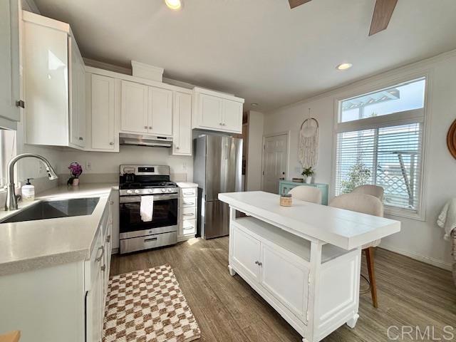 699 North Vulcan Avenue, Unit 80 Encinitas, CA 92024 - Photo 16 of 27 a kitchen with stainless steel appliances a sink a stove a refrigerator cabinets and a center island