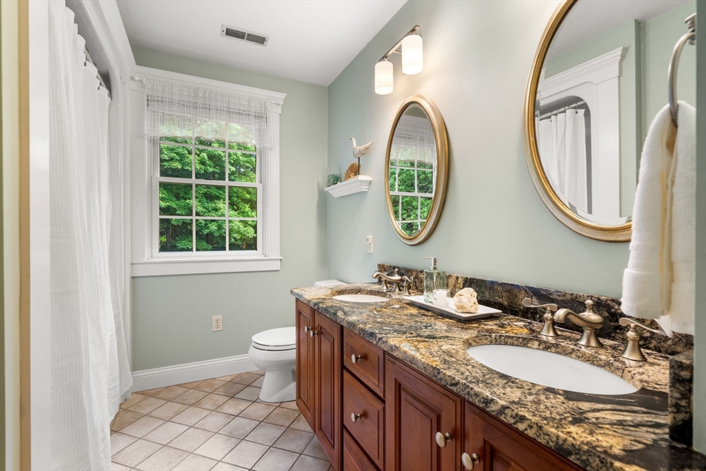 338 Pond Street Dunstable, MA 01827 - Photo 29 of 42 a bathroom with a granite countertop toilet a sink and a mirror