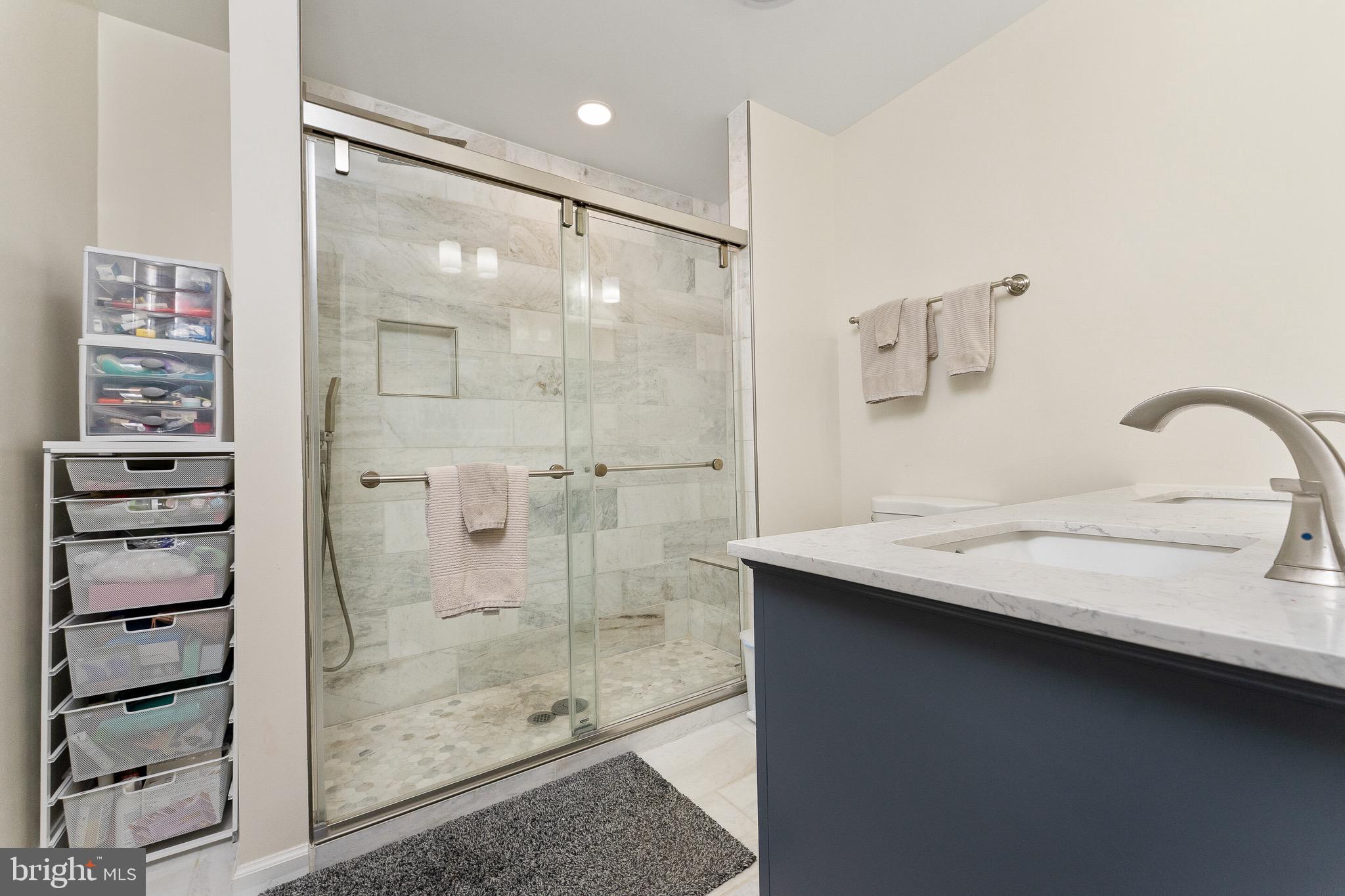 2425 Hunter Mill Road Vienna, VA 22181 - Photo 14 of 28 a bathroom with a shower sink and mirror
