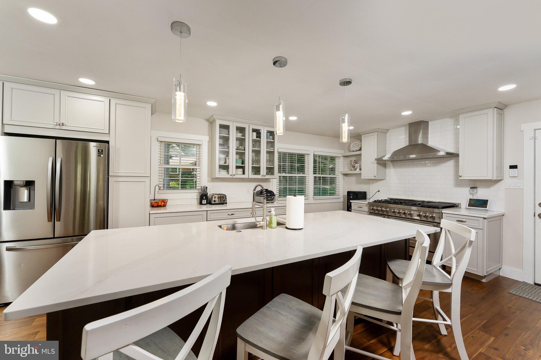 2425 Hunter Mill Road Vienna, VA 22181 - Photo 7 of 28 a kitchen with stainless steel appliances kitchen island granite countertop a table chairs stove top oven and refrigerator