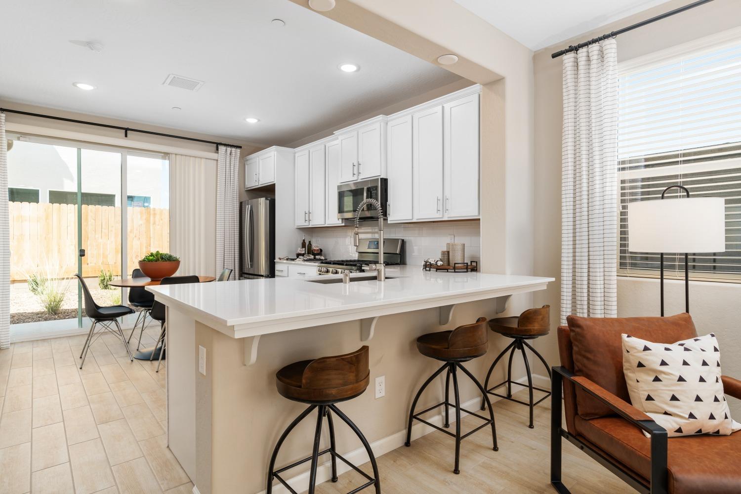 1116 Elevations Way West Madera, CA 93636 - Photo 7 of 20 a kitchen with stainless steel appliances a table and chairs in it