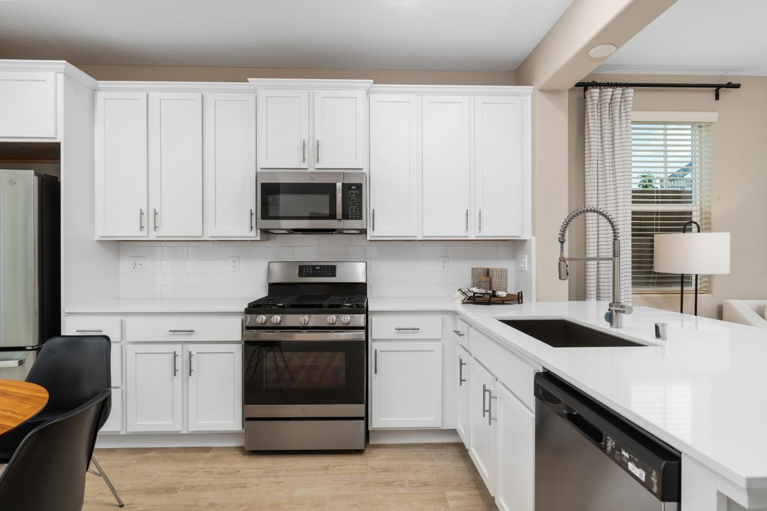 1116 Elevations Way West Madera, CA 93636 - Photo 8 of 20 a kitchen with white cabinets and appliances