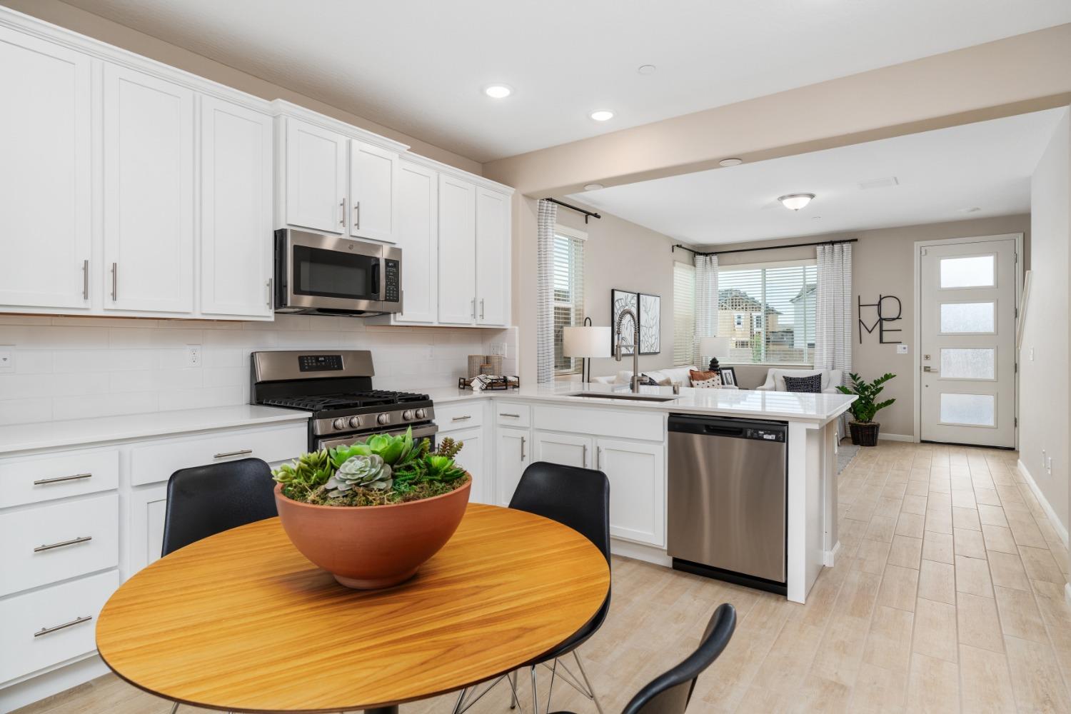 1116 Elevations Way West Madera, CA 93636 - Photo 10 of 20 a kitchen with kitchen island a stove a sink and a white cabinets
