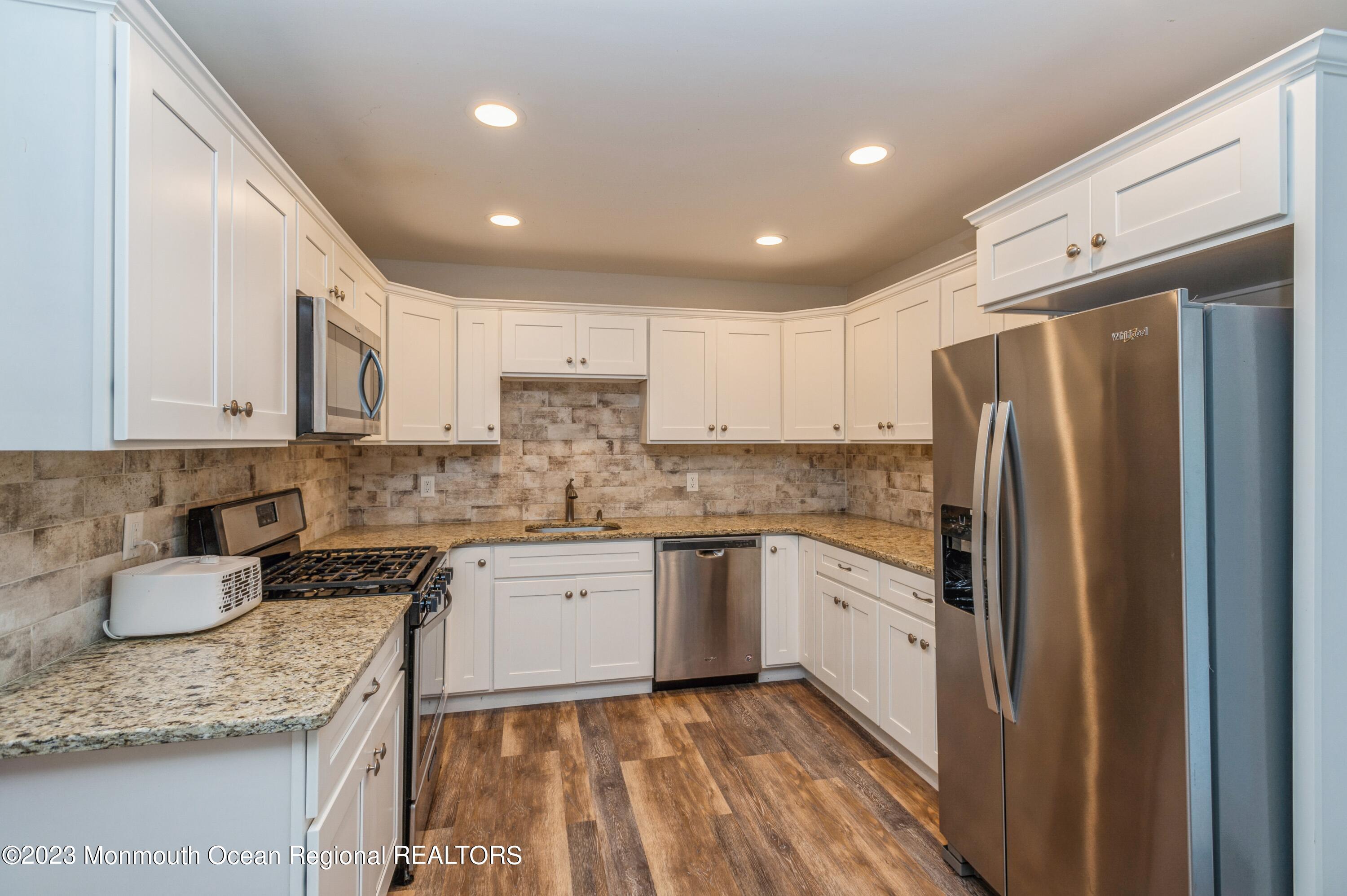 121 Darien Road Howell, NJ 07731 - Photo 2 of 19 a kitchen with granite countertop kitchen island stainless steel appliances a refrigerator sink and cabinets